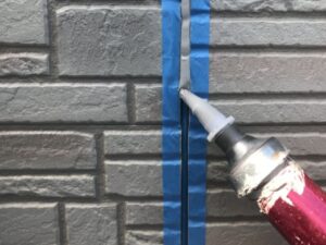 外壁目地にシーリングの充填を行っている様子